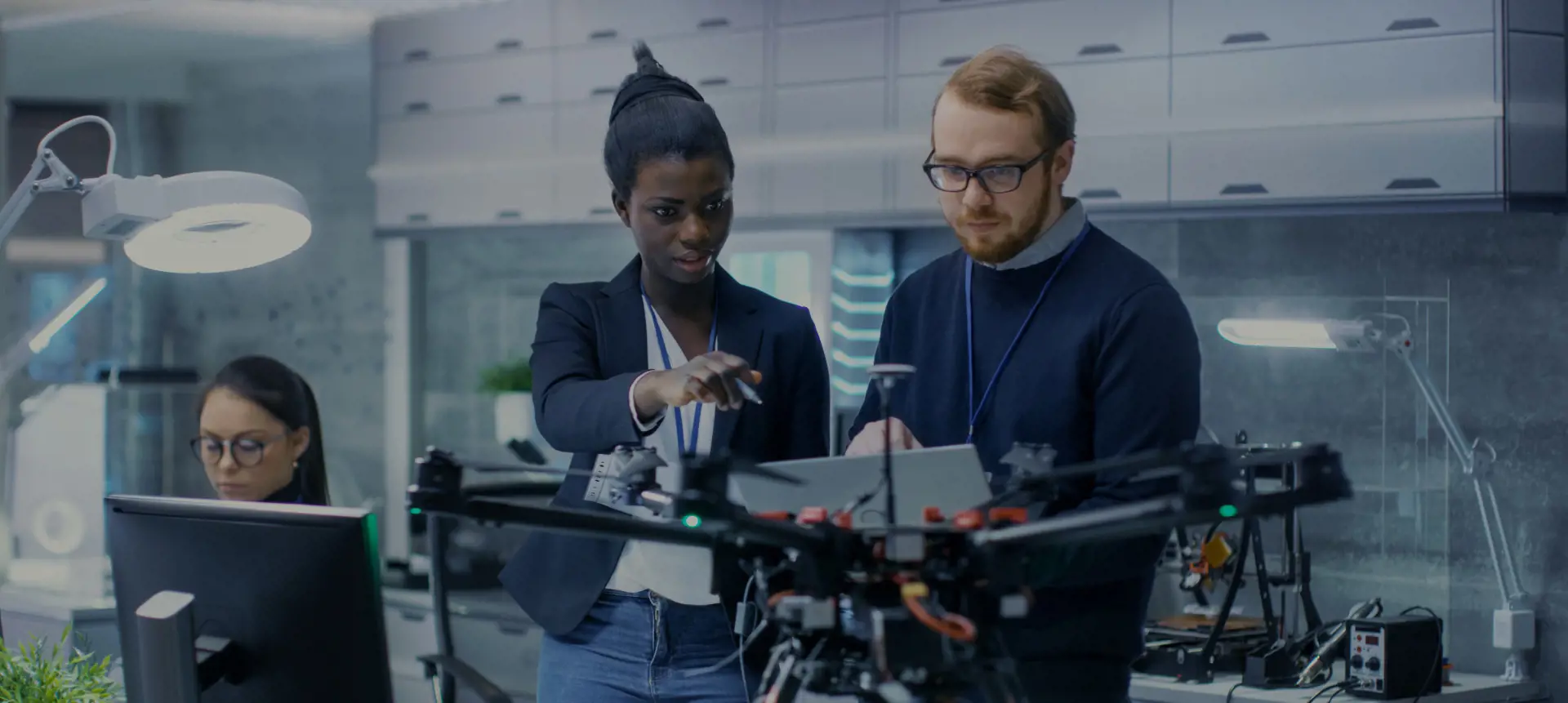 People in lanyards pointing at a laptop
