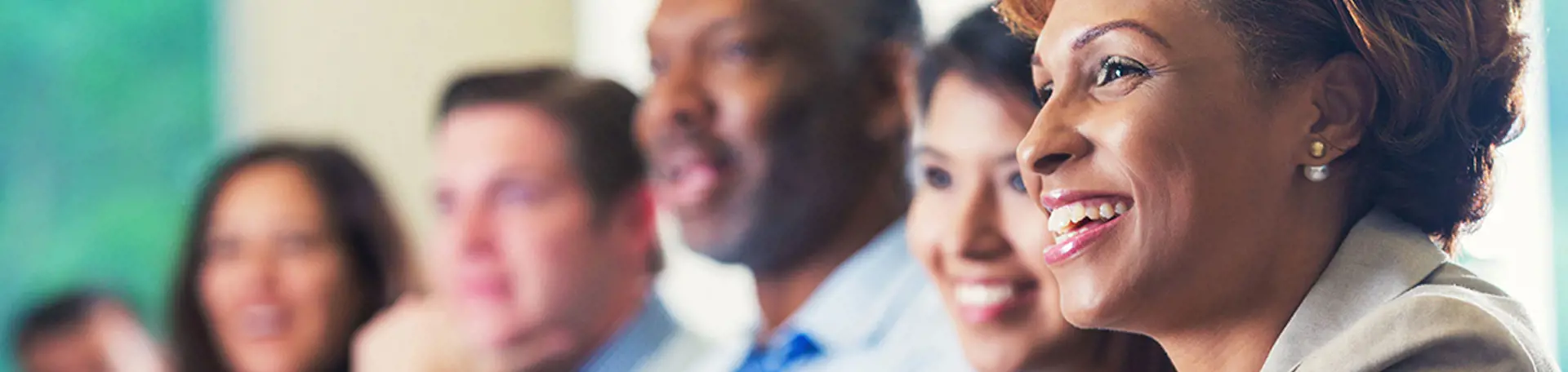 Several corporate people listening to a speaker